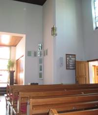 Quelle: Annette Wohlfeil Blick in den Kirchenraum, mit Bänken, Taufkreut und Liedertafel