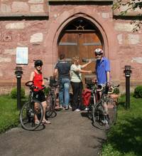 Quelle: Tourismusverband liebliches Taubertal Gruppe von Radfahreren stehen vor einer Kirche
